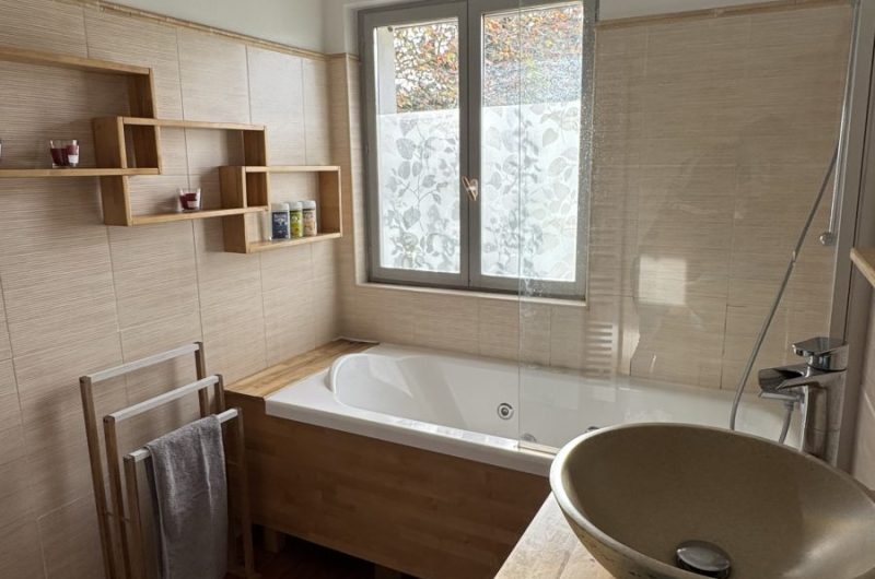 Salle de bains avec baignoire balnéo et double vasque